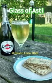 Bottle of Martini Asti with a glass of Asti set on a picnic bench in ColourMine's garden