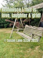 Wooden garden swing hanging from a timber frame on a grassy lawn, surrounded by green plants and flowers. The swing is empty, suggesting a quiet moment of reflection. Overlaid text reads: “Reminisce  This is love, laughter & grief © Susan Lane SLCM 2025.”