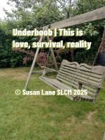 A wooden garden swing hangs from a sturdy frame on a green lawn, surrounded by trees and flowering bushes. Overlaid text reads “Underboob | This is love, survival, reality © Susan Lane SLCM 2025.”